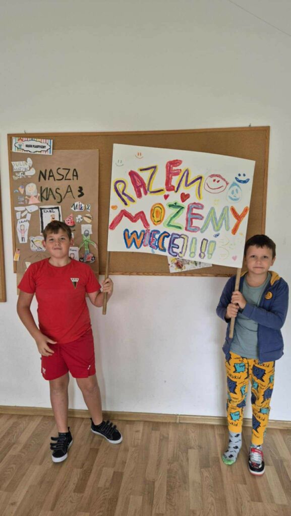 Na obrazku dwóch uczniów trzymających transparent "Razem możemy więcej" 