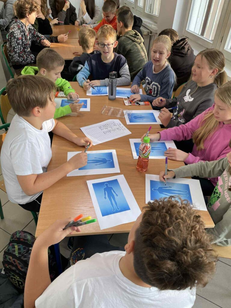 Grupa dzieci pracująca nad kartami pracy podczas warsztatów