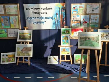 Wystawa z pracami konkursowymi na tle granatowego ekranu z nazwą konkusru