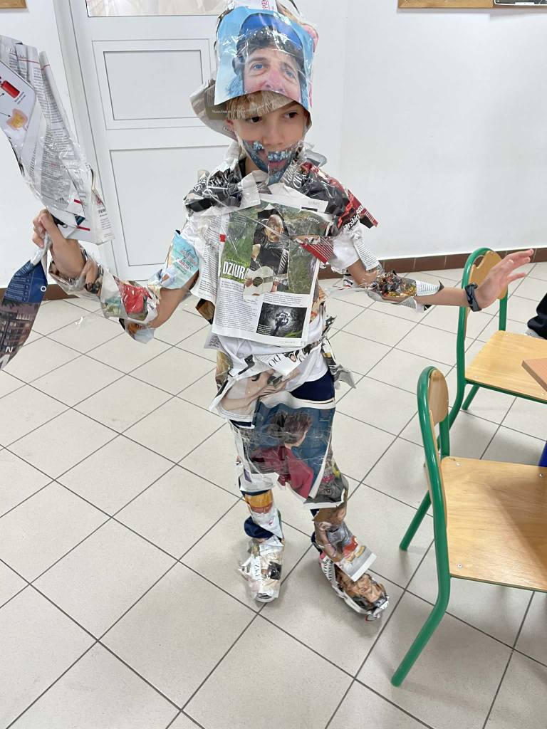 Uczeń cały obklejony gazetami